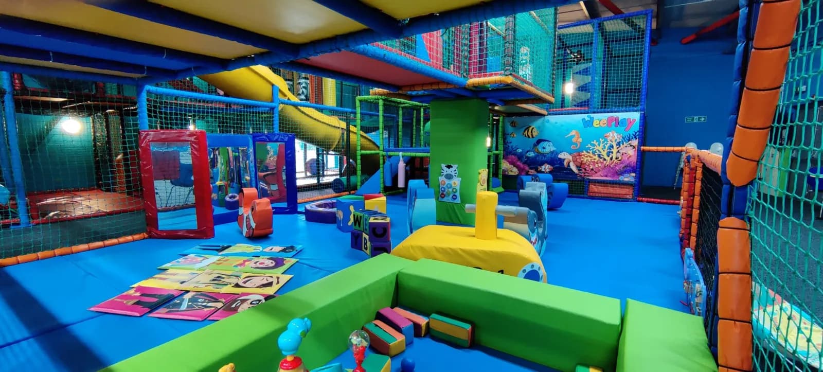 WeePlay's multi-level soft play frame with slides, ball pits and a green padded floor