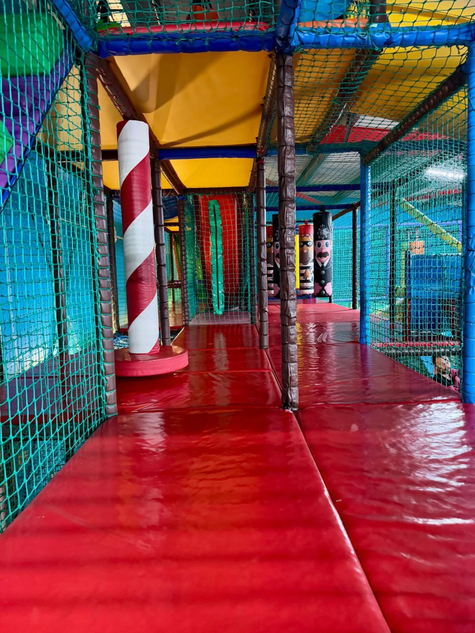A red padded walkway winding through the climbing frame