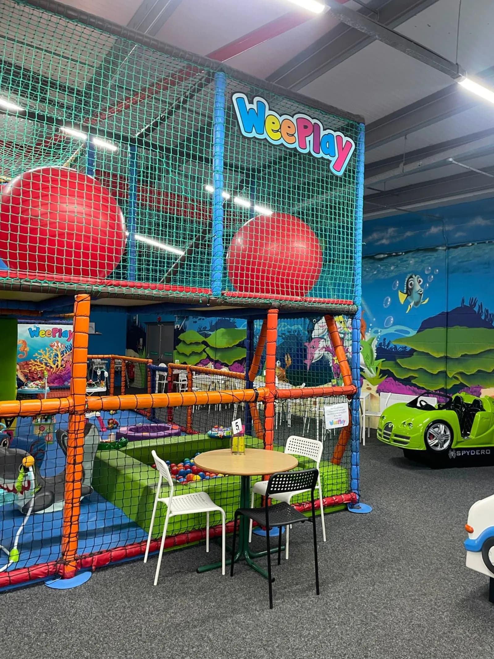 The WeePlay sign above the soft play frame and café tables